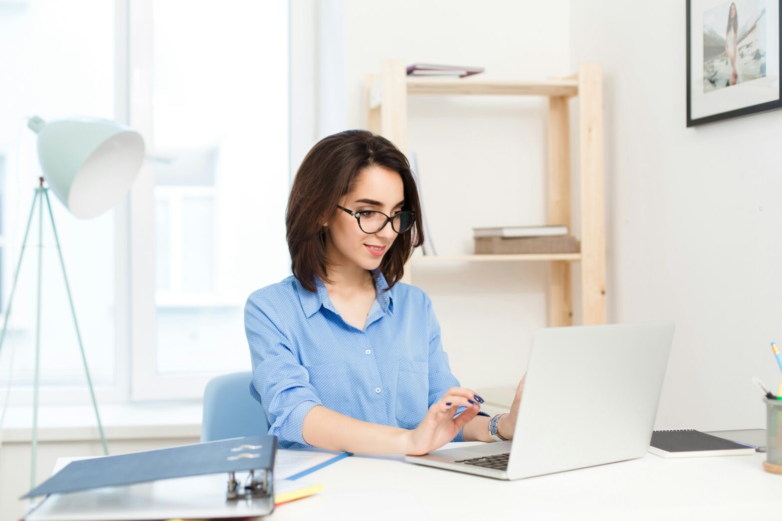 Women sitting at a desk working on a laptop computer.